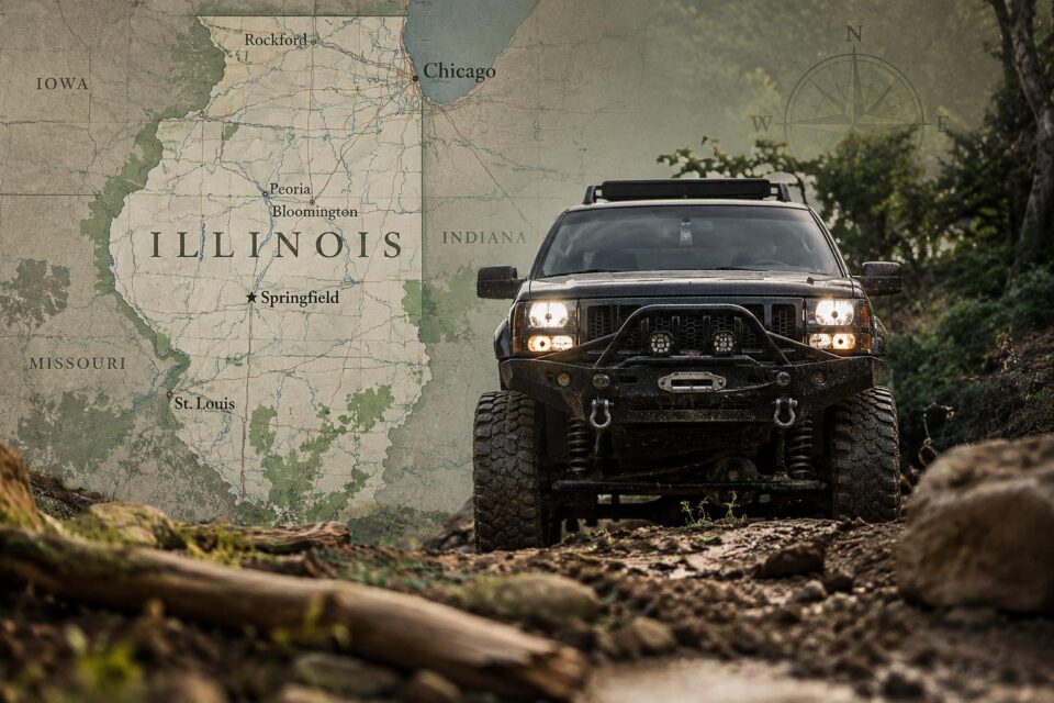 Lifted off-road truck on a rocky trail beside a map of Illinois