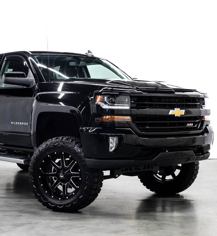 Black lifted Chevrolet truck viewed from the front